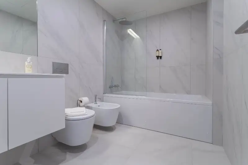 Marble tiled bathroom with bathtub and rain shower